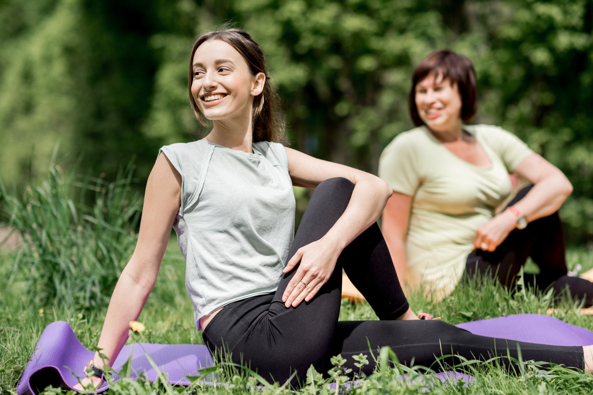 young-and-elder-woman-doing-yoga-in-the-park-2023-11-27-05-16-49-utc